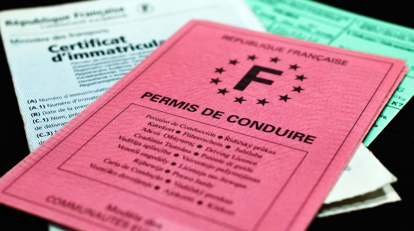 Gros plan sur un permis de conduire posé sur une table à côté d'un clavier d'ordinateur