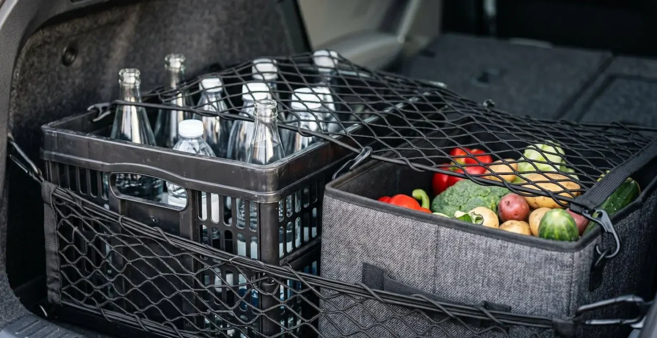Intérieur de coffre avec système de compartimentage modulaire combinant caisse rigide et filet de maintien